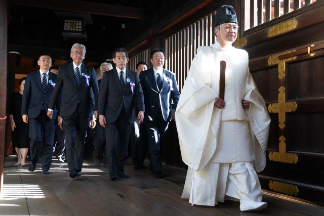 A Shinto priest leads parliament members to pray for the war dead at Yasukuni Shrine in Tokyo on April 22, 2026, as part of the shrine's three-day spring festival. (Photo by Kazuhiro NOGI / AFP)