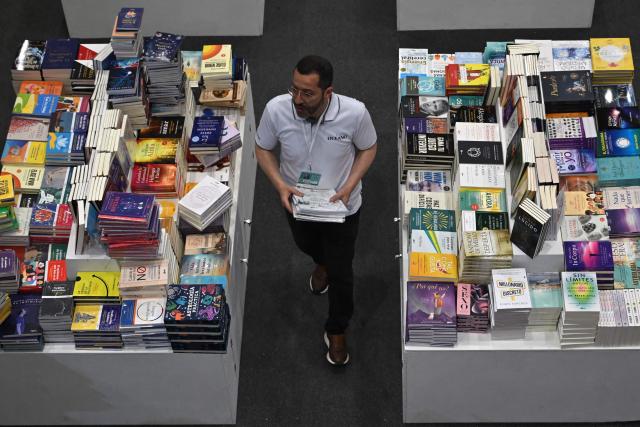 A man arranges books during the International Book Fair in Bogota on April 21, 2026. (Photo by Raul ARBOLEDA / AFP)