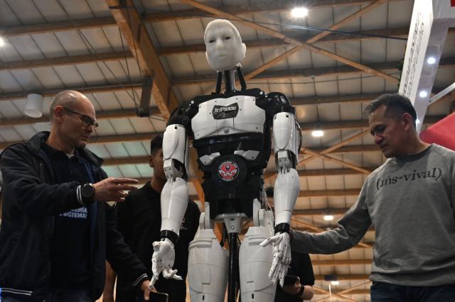 Members of a university test a robot at the International Book Fair in Bogota on April 21, 2026. (Photo by Raul ARBOLEDA / AFP)