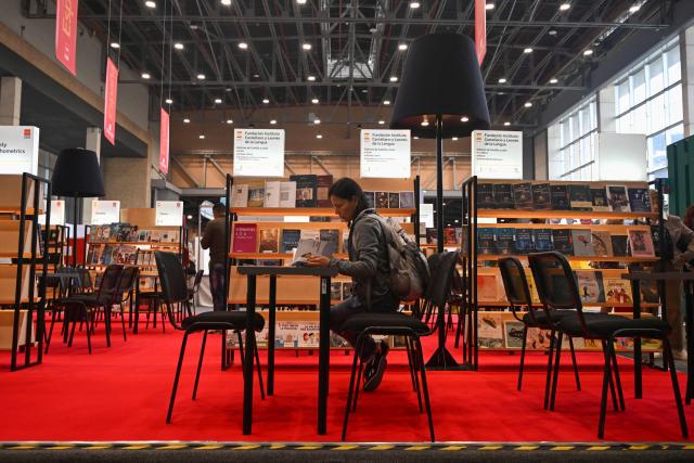 A woman reads a book at the International Book Fair in Bogota on April 21, 2026. (Photo by Raul ARBOLEDA / AFP)