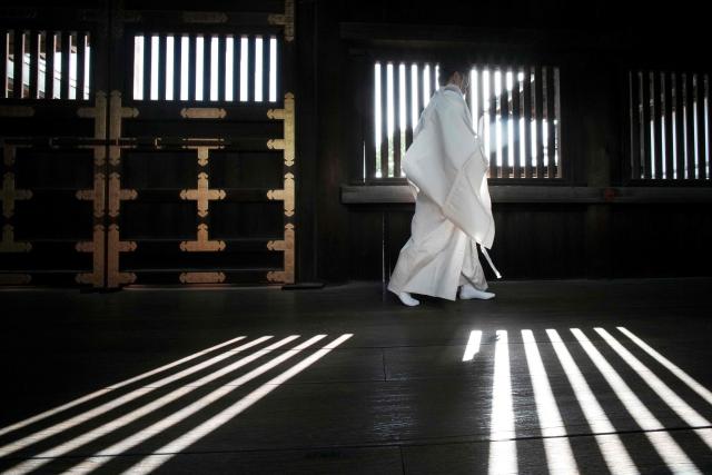 A Shinto priest walks along a corridor of Yasukuni Shrine in Tokyo on April 22, 2026. (Photo by Kazuhiro NOGI / AFP)