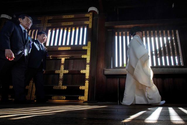 A Shinto priest leads parliament members to pray for the war dead at Yasukuni Shrine in Tokyo on April 22, 2026, as part of the shrine's three-day spring festival. (Photo by Kazuhiro NOGI / AFP)