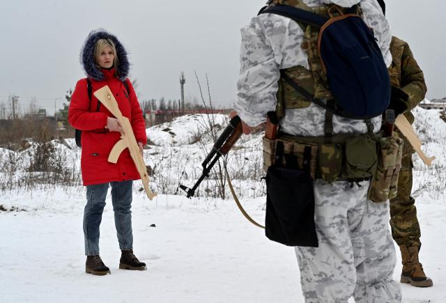 (FILES) A military instructor teaches civilians holding wooden replicas of Kalashnikov rifles, as they take part in a training session at an abandoned factory in the Ukrainian capital of Kyiv on February 6, 2022. Seven dead, police officers accused of fleeing the scene... April 19, 2026’s bloody and extremely rare shooting in Kyiv is providing ammunition for those who advocate the legalisation of firearms in Ukraine, which they claim would ensure greater security in a nation already traumatised by the war with Russia. (Photo by Sergei SUPINSKY / AFP)