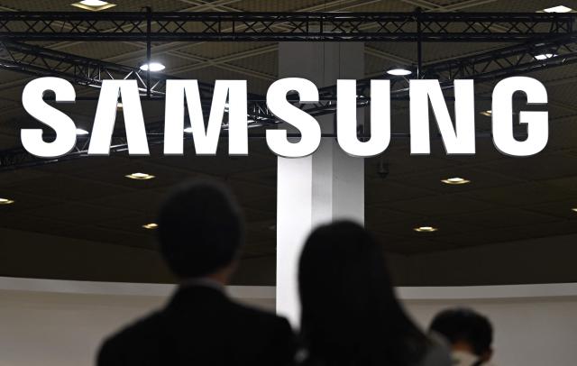 Visitors walk past the logo of Samsung Electronics during the 2026 World IT Show in Seoul on April 22, 2026. (Photo by Jung Yeon-je / AFP)