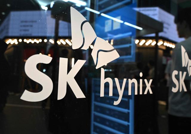 The logo of SK hynix is displayed on a glass wall during the 2026 World IT Show in Seoul on April 22, 2026. (Photo by Jung Yeon-je / AFP)