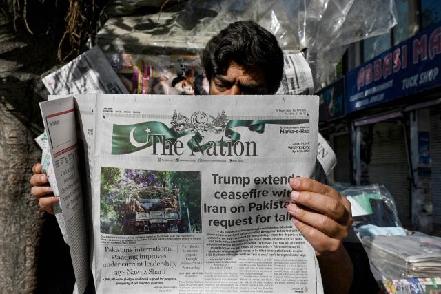 A man reads a newspaper with a front page article referring to anticipated US-Iran peace talks, at a stall in Islamabad on April 22, 2026. Pakistani Prime Minister Shehbaz Sharif thanked US President Donald Trump for extending a ceasefire with Iran and indefinitely pushing back the end of the two week truce, with Tehran silent on the decision early on April 22. (Photo by Asif HASSAN / AFP)
