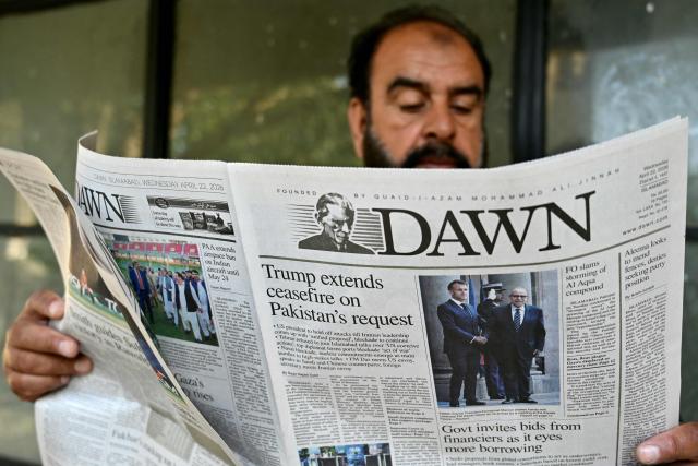 A man reads a newspaper with a front page article referring to anticipated US-Iran peace talks, at a stall in Islamabad on April 22, 2026. Pakistani Prime Minister Shehbaz Sharif thanked US President Donald Trump for extending a ceasefire with Iran and indefinitely pushing back the end of the two week truce, with Tehran silent on the decision early on April 22. (Photo by Asif HASSAN / AFP)