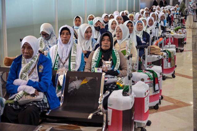 Indonesian pilgrims wait before departing for the holy city of Mecca to perform the annual Hajj, at Juanda International Airport in Sidoarjo on April 22, 2026. (Photo by JUNI KRISWANTO / AFP)