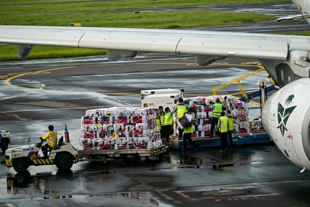 Workers load pilgrims’ luggages onto a Saudia Airlines plane before departing for the holy city of Mecca for the annual Hajj, at Juanda International Airport in Sidoarjo on April 22, 2026. (Photo by JUNI KRISWANTO / AFP)