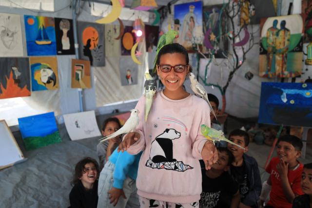 TOPSHOT - Displaced Palestinian children take part in psychological support sessions at an art studio that uses pets and birds in the Al-Zawaida area of the central Gaza Strip on April 21, 2026. (Photo by Eyad Baba / AFP)