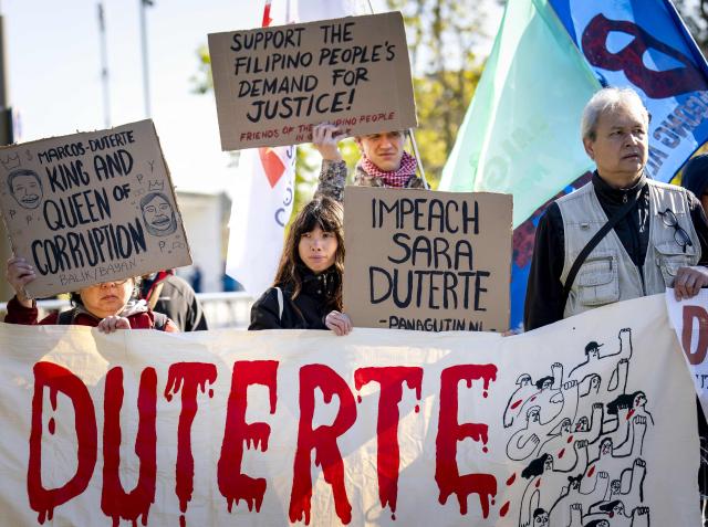 Protesters hold placards in front of the International Criminal Court (ICC) ahead of the ruling on the appeal by the former Philippines President Rodrigo Duterte. The activists are requesting the ICC to confirm its jurisdiction over the Duterte case and, by return of mail, the charges of crimes against humanity against Duterte. The 80-year-old himself was not present at the Court, reportedly because of his fragile health. (Photo by Sem van der Wal / ANP / AFP) / Netherlands OUT