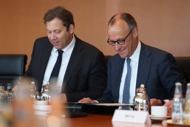 German Finance Minister and Vice Chancellor Lars Klingbeil (L) and Germany's Chancellor Friedrich Merz have taken their seats for the weekly cabinet meeting at the Chancellery in Berlin on April 22, 2026. (Photo by Odd ANDERSEN / AFP)
