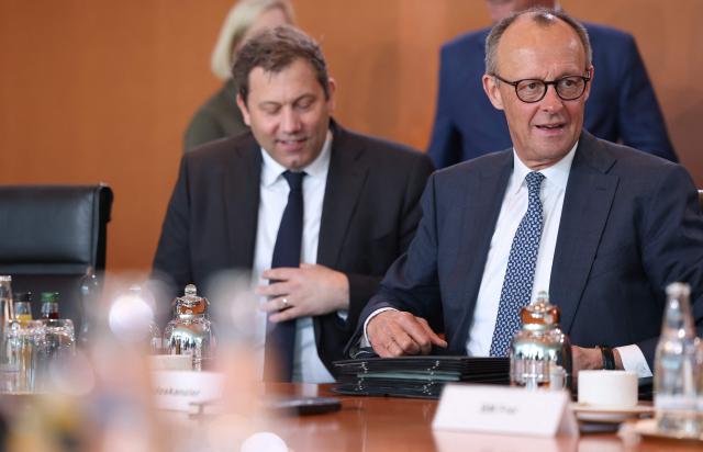 German Finance Minister and Vice Chancellor Lars Klingbeil (L) and Germany's Chancellor Friedrich Merz have taken their seats for the weekly cabinet meeting at the Chancellery in Berlin on April 22, 2026. (Photo by Odd ANDERSEN / AFP)