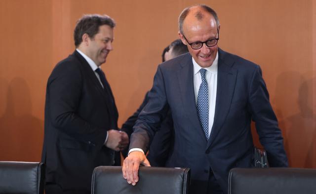 Germany's Chancellor Friedrich Merz (R) arrives for the weekly cabinet meeting at the Chancellery in Berlin on April 22, 2026. (Photo by Odd ANDERSEN / AFP)