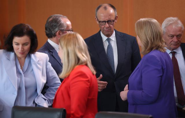 Germany's Chancellor Friedrich Merz (C) talks with ministers as they arrive for the weekly cabinet meeting at the Chancellery in Berlin on April 22, 2026. (Photo by Odd ANDERSEN / AFP)