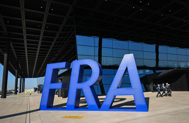 TOPSHOT - Police walk past the letters FRA outside the new Terminal 3 of Frankfurt's international airport on the day of its official inauguration on April 22, 2026 in Frankfurt, western Germany. (Photo by Kirill KUDRYAVTSEV / AFP)