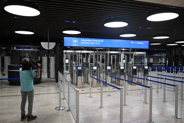 A cameraman films an automated border control at the Terminal 3 at the Frankfurt International airport on the day of the official inauguration of new Terminal 3 on April 22, 2026 in Frankfurt, western Germany. (Photo by Kirill KUDRYAVTSEV / AFP)