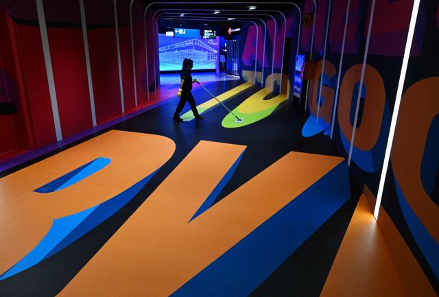 A woman cleans the way to the shopping area inside the new Terminal 3 of Frankfurt's international airport on the day of its official inauguration on April 22, 2026 in Frankfurt, western Germany. (Photo by Kirill KUDRYAVTSEV / AFP)