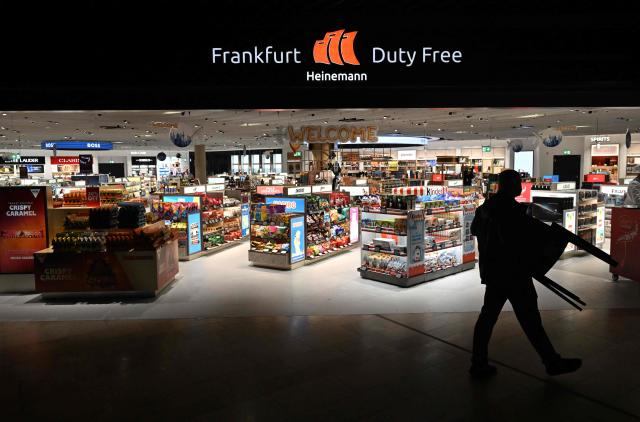 A person carries a chair past  the Heineman duty free shop inside the new Terminal 3 of Frankfurt's international airport on the day of its official inauguration on April 22, 2026 in Frankfurt, western Germany. (Photo by Kirill KUDRYAVTSEV / AFP)