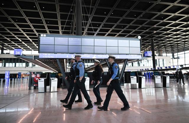Police walk at the check-in counters at the Terminal 3 at the Frankfurt International airport on the day of the official inauguration of new Terminal 3 on April 22, 2026 in Frankfurt, western Germany. (Photo by Kirill KUDRYAVTSEV / AFP)