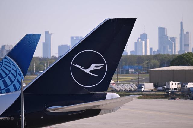 The logo of German airline Lufthansa is pictured from the Terminal 3 backdropped by the skyline of Frankfurt am Main at the Frankfurt International airport on the day of the official inauguration of new Terminal 3 on April 22, 2026 in Frankfurt, western Germany. (Photo by Kirill KUDRYAVTSEV / AFP)