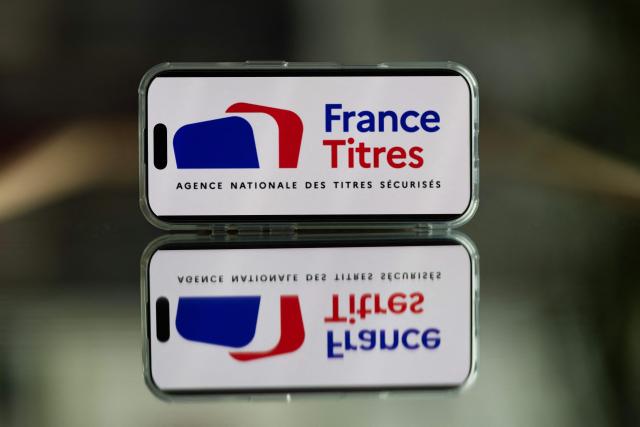 This photograph shows the France Titres logo, of the Agence Nationale des Titres Securises ANTS (France's National Agency for Secure Documents), displayed on a telephone screen in Quimper, western France, on April 22, 2026. (Photo by Fred TANNEAU / AFP)