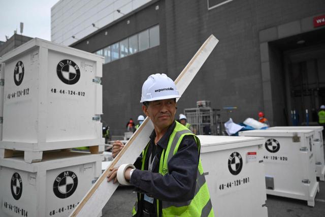 Workers assemble a stand for German automaker BMW ahead of the Beijing Auto Show 2026 at the China International Exhibition Center in Beijing on April 22, 2026. (Photo by Pedro PARDO / AFP)