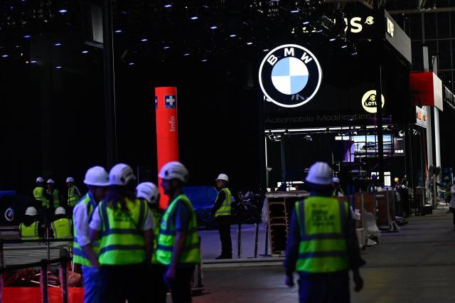 Workers assemble the stand for German carmaker BMW ahead of the Beijing Auto Show 2026 at the China International Exhibition Center in Beijing on April 22, 2026. (Photo by Pedro PARDO / AFP)