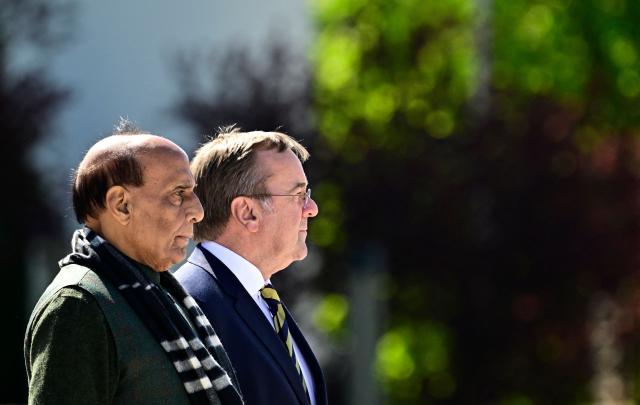 German Defence Minister Boris Pistorius (R) and his Indian counterpart Rajnath Singh listen to their national anthems as they review a military honor guard during a welcoming ceremony at the Defence Ministry in Berlin, on April 22, 2026. (Photo by Tobias SCHWARZ / AFP)