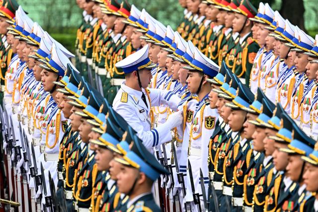 Members of a Vietnamese honour guard prepare ahead of a welcome ceremony for South Korean President Lee Jae Myung at the Presidential Palace in Hanoi on April 22, 2026. (Photo by Nhac NGUYEN / POOL / AFP)