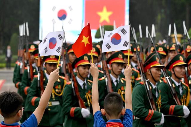 Members of a guard of honour at a welcome ceremony for South Korean President Lee Jae Myung and Vietnam's President To Lam at the Presidential Palace in Hanoi on April 22, 2026. (Photo by Nhac NGUYEN / POOL / AFP)