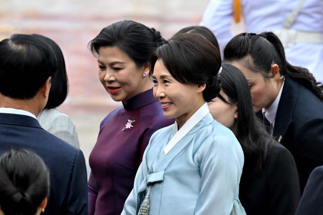 Ngo Phuong Ly (L), wife of Vietnam's President To Lam, and Kim Hea Kyung, wife of South Korean President Lee Jae Myung, attend a welcoming ceremony at the Presidential Palace in Hanoi on April 22, 2026. (Photo by Nhac NGUYEN / POOL / AFP)