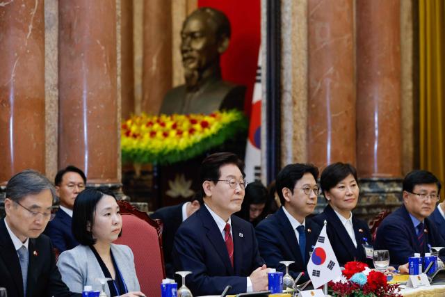 South Korean President Lee Jae Myung (C) and his delegation meets with Vietnam's President To Lam at the Presidential Palace in Hanoi on April 22, 2026. Vietnam's top leader To Lam, who became president in early April assuming a dual role as head of state and of the ruling Communist Party, hosted South Korean President Lee Jae Myung in Hanoi on April 22, a meeting that was expected to yield multiple cooperative agreements. (Photo by LUONG THAI LINH / POOL / AFP)
