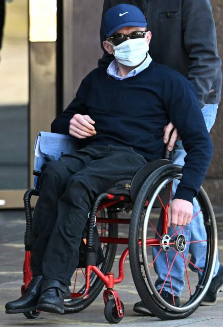 Mark Mogan, who is accused of racially abusing football player Antoine Semenyo - then with Bournemouth and now with Manchester City - during a match in August 2025, is pushed in a wheelchair as leaves Liverpool Magistrates' Court in Liverpool, north-west England on April 22, 2026, after case was adjourned until May 1. (Photo by Paul ELLIS / AFP)