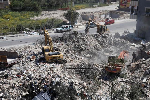 Rescue teams work to remove rubble from a building previously hit by the Israeli army, in the southern Lebanese village of Hanaouay on April 22, 2026. Israel and Lebanon, which have no diplomatic relations, will hold fresh talks in Washington on April 23, 2026, a State Department official told AFP. Israel conducted huge airstrikes across Lebanon and invaded the south after Hezbollah entered the Middle East war in support of its backer Iran on March 2. (Photo by Kawnat HAJU / AFP)