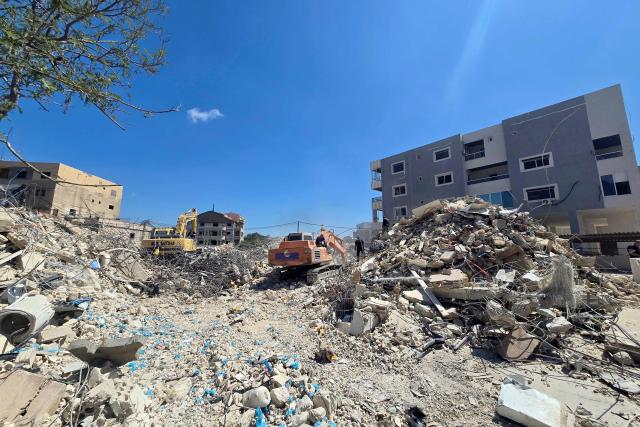 Diggers are used by rescue teams working to remove the rubble from a building previously hit by the Israeli army, in the southern Lebanese village of Hanaouay on April 22, 2026. Israel and Lebanon, which have no diplomatic relations, will hold fresh talks in Washington on April 23, 2026, a State Department official told AFP. Israel conducted huge airstrikes across Lebanon and invaded the south after Hezbollah entered the Middle East war in support of its backer Iran on March 2. (Photo by Kawnat HAJU / AFP)