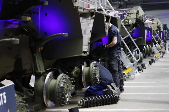 Employees work at 8x8 wheeled armoured personnel carrier Boxer during the opening of a new production line of Boxer armoured fighting vehicles produced by pan-European defense company KNDS in Munich on April 22, 2026. (Photo by Michaela STACHE / AFP)