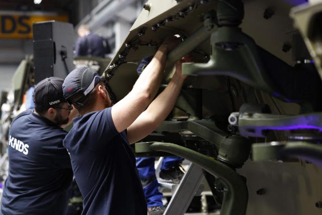 Employees work at 8x8 wheeled armoured personnel carrier Boxer during the opening of a new production line of Boxer armoured fighting vehicles produced by pan-European defense company KNDS in Munich on April 22, 2026. (Photo by Michaela STACHE / AFP)