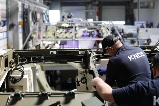 Employees work at 8x8 wheeled armoured personnel carrier Boxer during the opening of a new production line of Boxer armoured fighting vehicles produced by pan-European defense company KNDS in Munich on April 22, 2026. (Photo by Michaela STACHE / AFP)