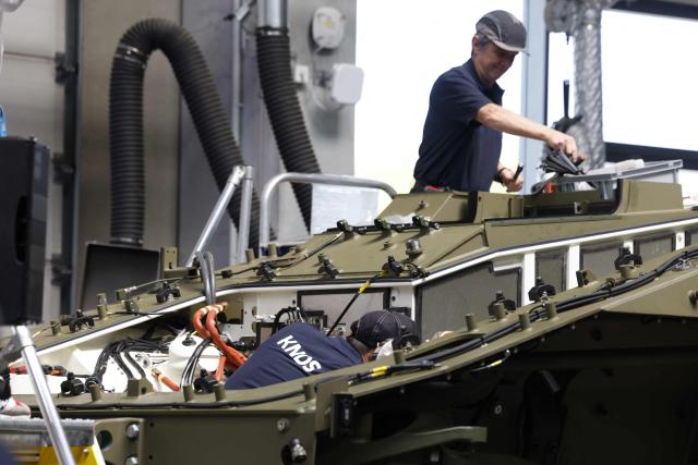 Employees work at 8x8 wheeled armoured personnel carrier Boxer during the opening of a new production line of Boxer armoured fighting vehicles produced by pan-European defense company KNDS in Munich on April 22, 2026. (Photo by Michaela STACHE / AFP)