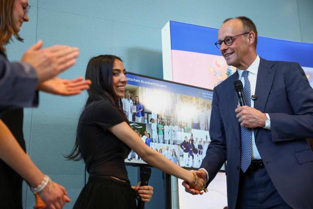 German Chancellor Friedrich Merz (R) shakes hands with a young woman as he hosts the opening event of the annual "Girls' Day", a nationwide initiative empowering young women and girls to explore diverse career paths, at the Chancellery in Berlin, Germany April 22, 2026. (Photo by Lisi Niesner / POOL / AFP)