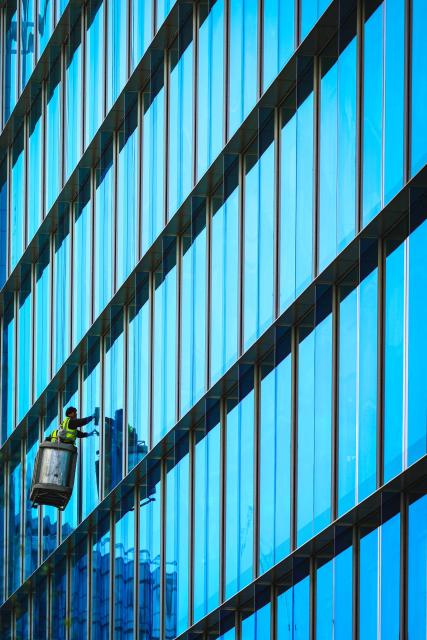 Workers suspended in a cradle clean the windows of an office building in Paddington Central in London on April 22, 2026. (Photo by ADRIAN DENNIS / AFP)