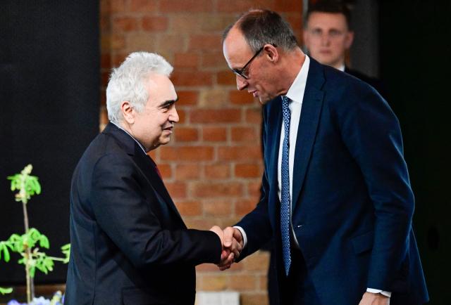 Executive Director of the International Energy Agency (IEA) Fatih Birol (L) shakes hands with German Chancellor Friedrich Merz after delivering a speech during the Petersberg Climate Dialogue (PCD) conference, on April 22, 2026 at the Westhafen Convention Center (WECC) in Berlin. The Petersberg Climate Dialogue is the first major COP31-related event that will be held in Antalya, Turkey, from November 9 to 20, 2026. (Photo by John MACDOUGALL / AFP)