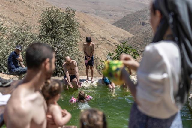 Israelis enjoy the Palestinian water spring of Ein al-Rashash as they celebrate the Israeli Independence Day at the settlement of Malachei HaShalom, northeast of Ramallah in the occupied West Bank, on April 22, 2026. (Photo by ilia YEFIMOVICH / AFP)