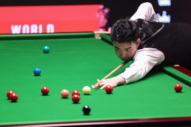 China's Si Jiahui plays a shot against Iran's Hossein Vafaei (not pictured) during their World Snooker Championship Round One match at The Crucible in Sheffield, northern England on April 22, 2026. The World Snooker Championship 2025 will take place from April 19 to May 5, 2025. (Photo by Darren Staples / AFP)
