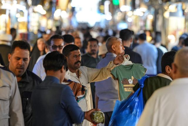 A street vendor sells T-shirts at a market in the Old City of Najaf on April 22, 2026. The International Monetary Fund sharply reduced its 2026 growth forecast for the Middle East and North Africa to 1.1 percent on April 14, as war chokes Gulf oil and gas exports. Iran, Iraq and Qatar will be particularly hard-hit, the IMF's World Economic Outlook warned, with Iraq’s economy projected to contract by 6.8 percent. (Photo by Qassem al-KAABI / AFP)