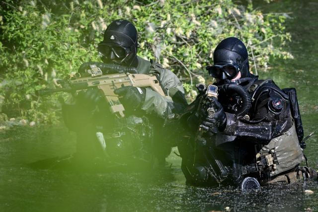 France's army combat divers from the 3rd Engineer Regiment take part in a training session by Lake Amance, with the support of Belgium’s army combat divers, as part of the ORION 26 military exercise in Radonvilliers, northeastern France, on April 22, 2026. (Photo by Jean-Christophe VERHAEGEN / AFP)