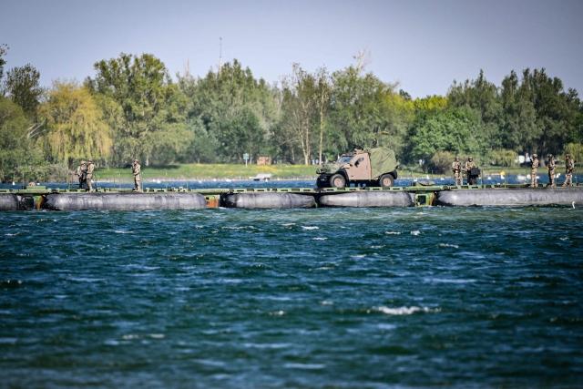 Members of France's 3rd Engineer Regiment deploy a forward crossing apparatus (also known as EFA or Engin de Franchissement de l'Avant) to allow members of France's 1st Tirailleur Regiment to cross Lake Amance, during a training session as part of the ORION 26 military exercise in Radonvilliers, northeastern France, on April 22, 2026. (Photo by Jean-Christophe VERHAEGEN / AFP)