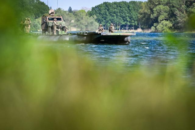 Members of France's 3rd Engineer Regiment deploy a forward crossing apparatus (also known as EFA or Engin de Franchissement de l'Avant) to allow members of France's 1st Tirailleur Regiment to cross Lake Amance, during a training session as part of the ORION 26 military exercise in Radonvilliers, northeastern France, on April 22, 2026. (Photo by Jean-Christophe VERHAEGEN / AFP)