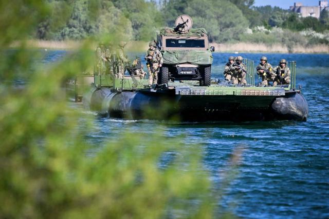 Members of France's 3rd Engineer Regiment deploy a forward crossing apparatus (also known as EFA or Engin de Franchissement de l'Avant) to allow members of France's 1st Tirailleur Regiment to cross Lake Amance, during a training session as part of the ORION 26 military exercise in Radonvilliers, northeastern France, on April 22, 2026. (Photo by Jean-Christophe VERHAEGEN / AFP)